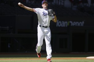 Texas Rangers starting pitcher Max Scherzer throws to first during fielding practice in Arlington, Texas, Friday, Oct. 13, 2023.