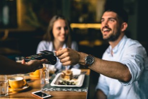 A couple buys dinner with a credit card.