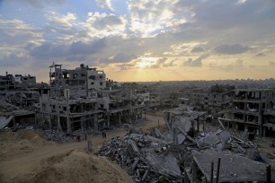 Palestinians walk between the rubble of a destroyed building in Shijaiyah neighborhood of Gaza City in the northern Gaza Strip, Oct. 12, 2014.