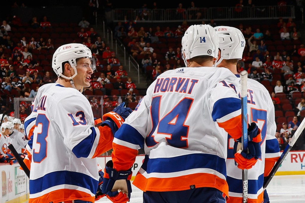 Mat Barzal celebrates with Bo Horvat and Anders Lee after scoring a goal during an Islanders preseason game.